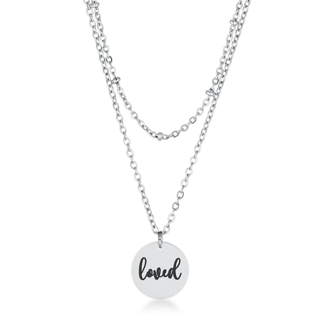 This classy necklace features a simple oval pendant inscribed with LOVED hanging from a cable chain. An inner saturn chain adds sophistication to